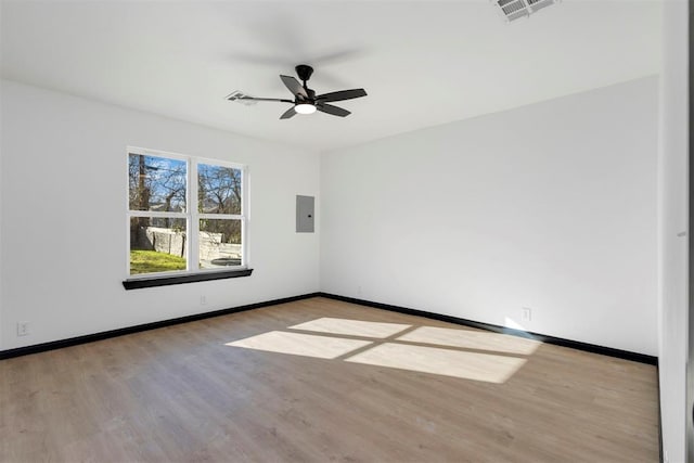 unfurnished room featuring light wood-type flooring, ceiling fan, and electric panel