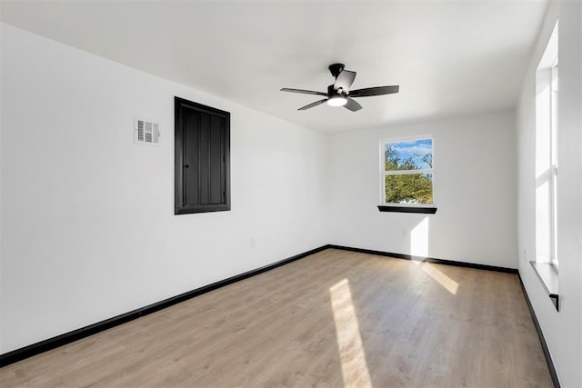 empty room with ceiling fan and light hardwood / wood-style flooring