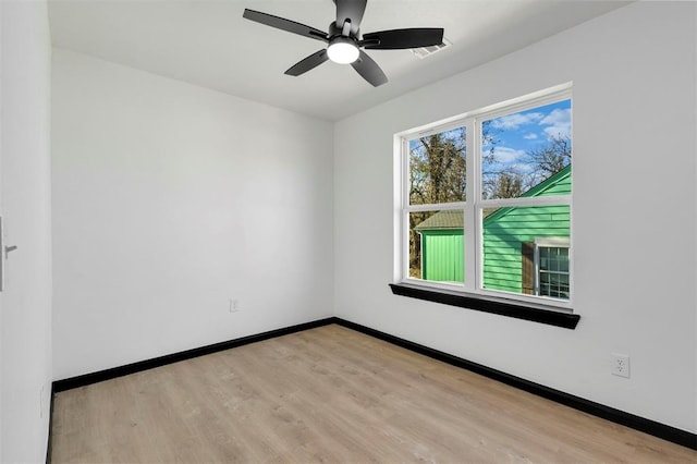 empty room with ceiling fan and light hardwood / wood-style flooring