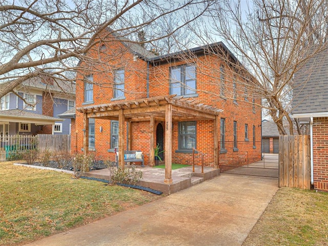 view of front of home with a pergola, a front lawn, and a patio