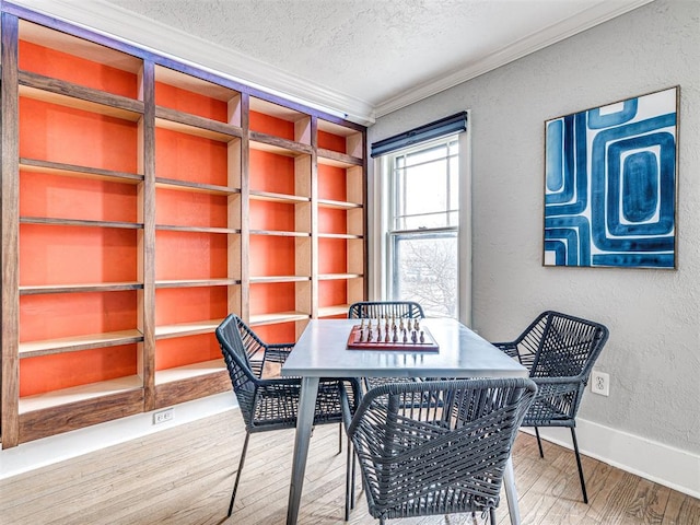 dining room featuring crown molding, hardwood / wood-style floors, a textured ceiling, and built in shelves