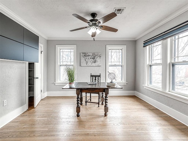 office space featuring a textured ceiling, ornamental molding, light hardwood / wood-style floors, and ceiling fan