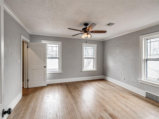 unfurnished room featuring crown molding, a textured ceiling, and light wood-type flooring