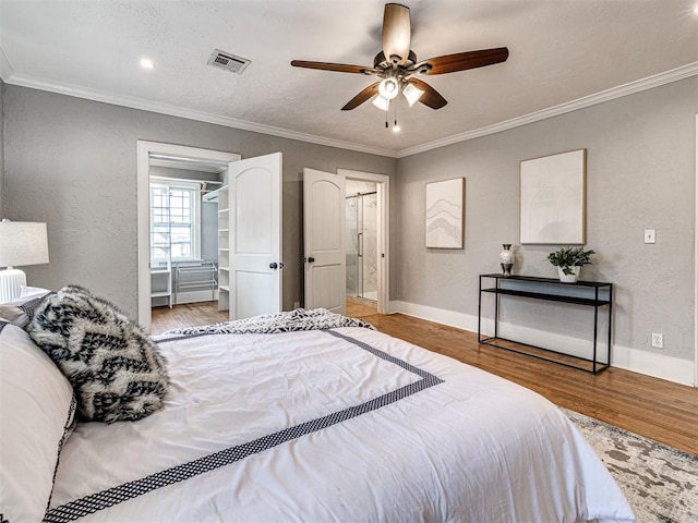 bedroom featuring wood-type flooring, crown molding, and ceiling fan