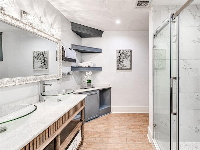 bathroom with vanity and a shower with door