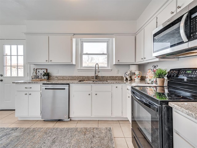 kitchen featuring sink, white cabinetry, light tile patterned floors, and appliances with stainless steel finishes