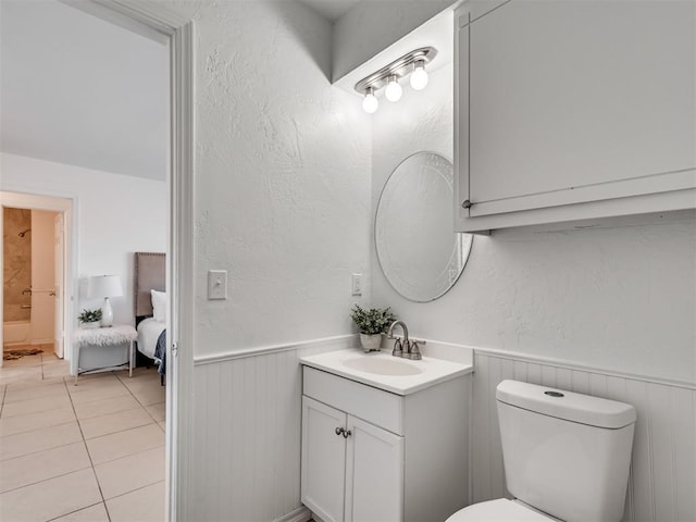 bathroom with toilet, tile patterned floors, and vanity