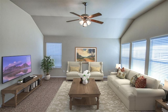 carpeted living room with ceiling fan and vaulted ceiling