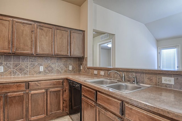 kitchen featuring dishwasher, vaulted ceiling, sink, and decorative backsplash