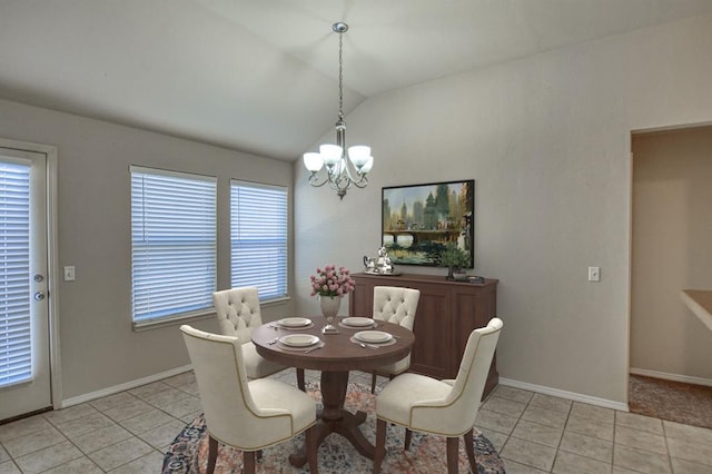 tiled dining room with a healthy amount of sunlight, lofted ceiling, and a chandelier