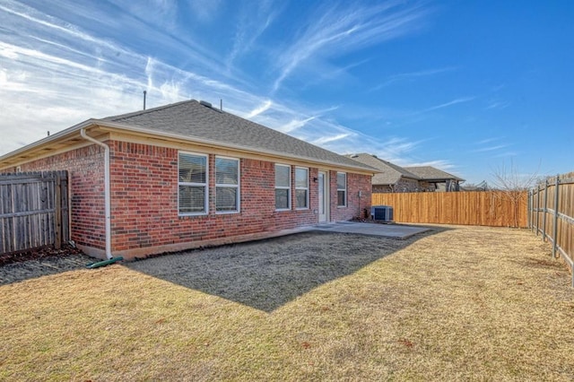 rear view of house featuring a patio area, central air condition unit, and a lawn