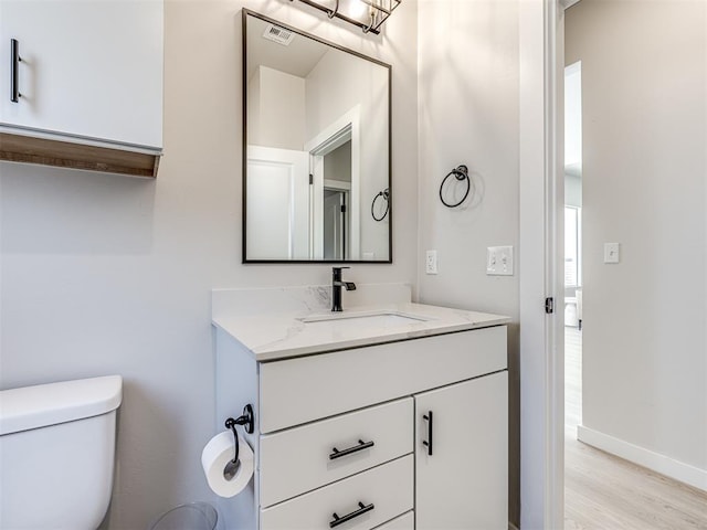 bathroom featuring vanity, toilet, and hardwood / wood-style floors