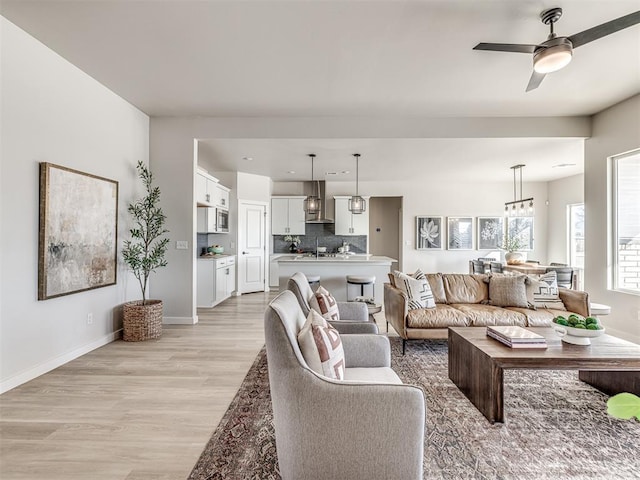 living room featuring ceiling fan and light hardwood / wood-style floors