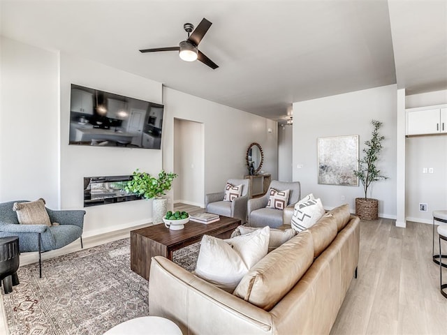 living room with ceiling fan and light hardwood / wood-style floors