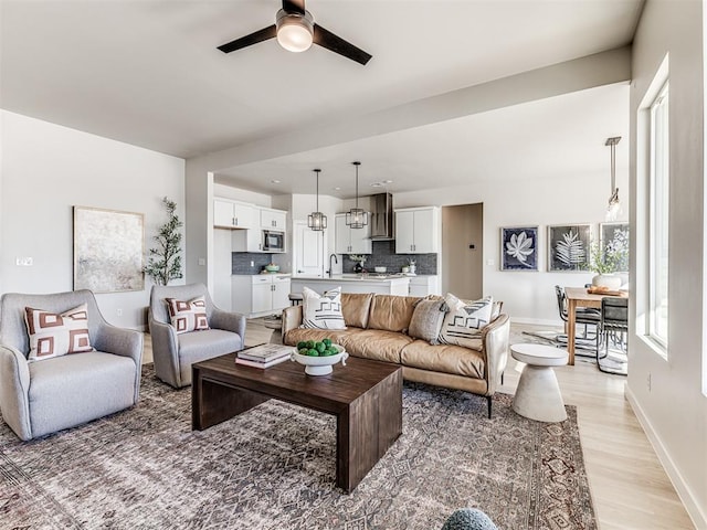 living room with ceiling fan and light wood-type flooring