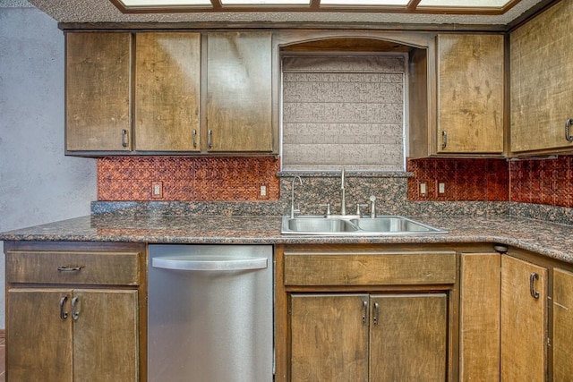 kitchen with decorative backsplash, sink, dishwasher, and dark stone counters