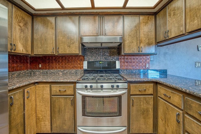 kitchen with dark stone countertops, appliances with stainless steel finishes, and tasteful backsplash