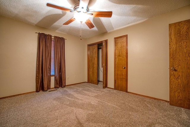 unfurnished bedroom with ceiling fan, carpet, and a textured ceiling