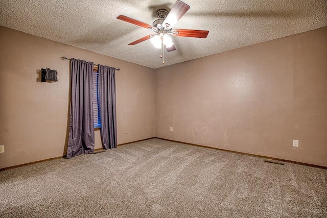 carpeted spare room featuring a textured ceiling and ceiling fan