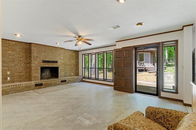 living room featuring brick wall, plenty of natural light, a brick fireplace, and a textured ceiling