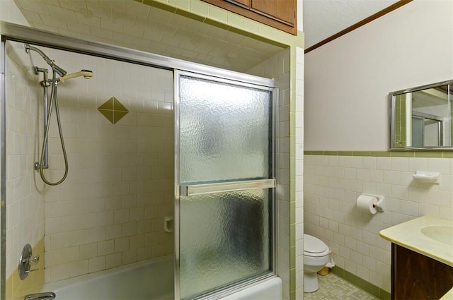 full bathroom featuring enclosed tub / shower combo, vanity, toilet, and tile walls