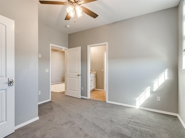 unfurnished bedroom featuring carpet floors, ensuite bath, and ceiling fan