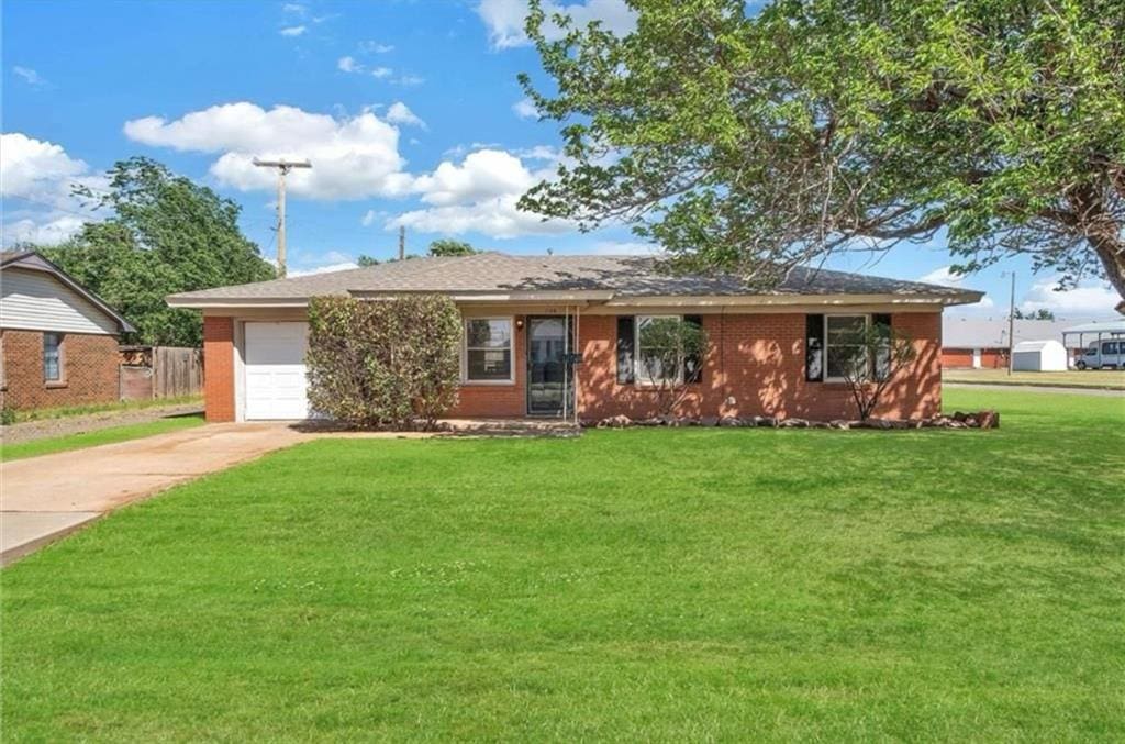 single story home featuring a garage and a front lawn