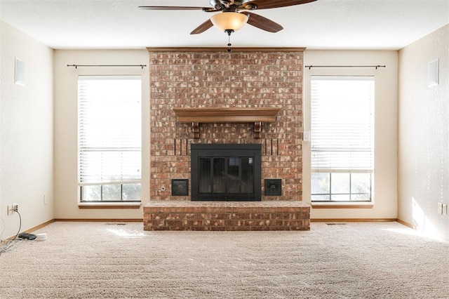 unfurnished living room featuring a fireplace, carpet floors, and ceiling fan