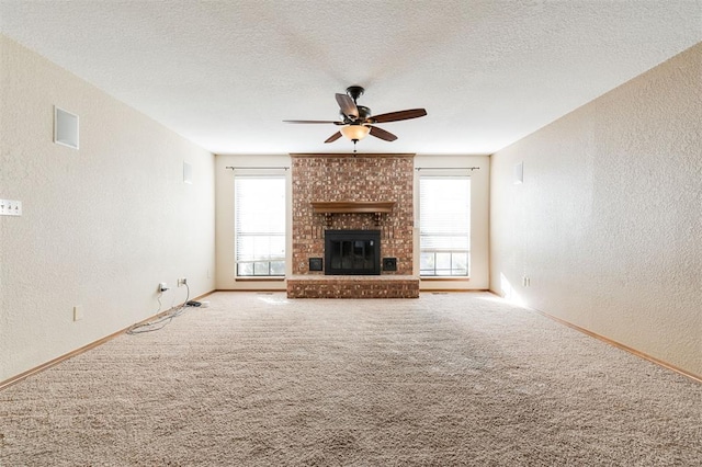 unfurnished living room featuring a brick fireplace, a textured ceiling, and carpet floors