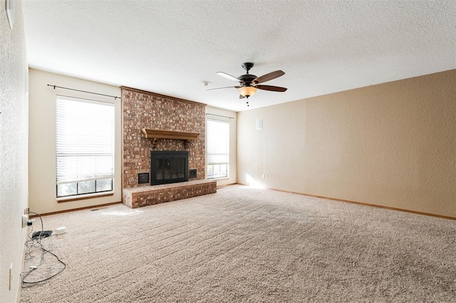 unfurnished living room with a fireplace, plenty of natural light, carpet flooring, and a textured ceiling