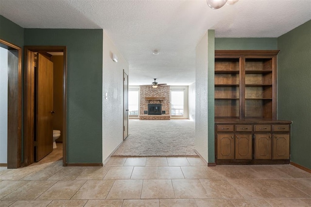 corridor featuring a textured ceiling and light tile patterned flooring