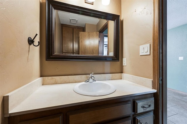 bathroom featuring a textured ceiling and vanity