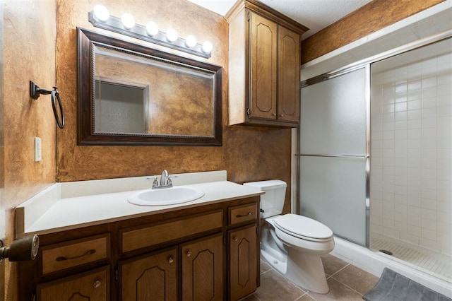 bathroom featuring tile patterned flooring, toilet, vanity, and walk in shower