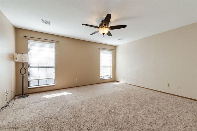 carpeted spare room featuring ceiling fan