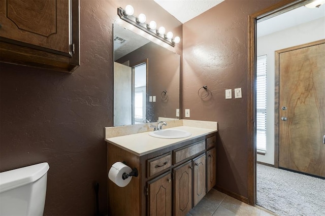 bathroom featuring toilet, tile patterned floors, and vanity