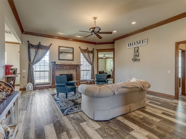 living room with hardwood / wood-style flooring, ceiling fan, and ornamental molding