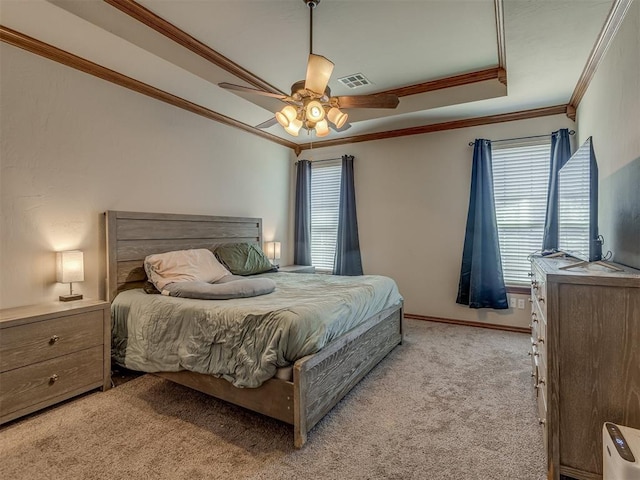 bedroom with ceiling fan, ornamental molding, a raised ceiling, and light colored carpet