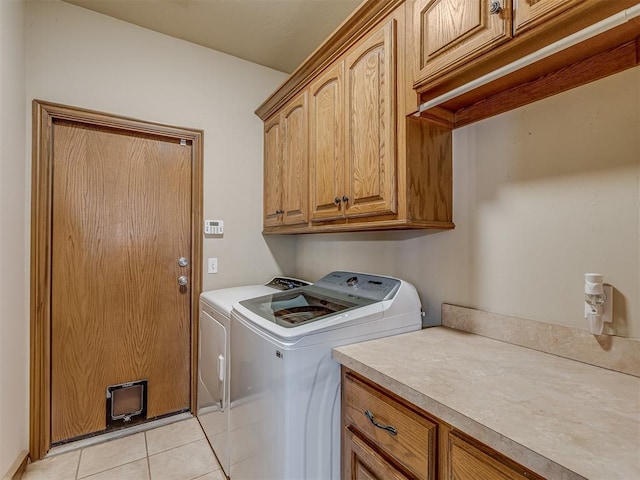 laundry area with cabinets, light tile patterned floors, and independent washer and dryer