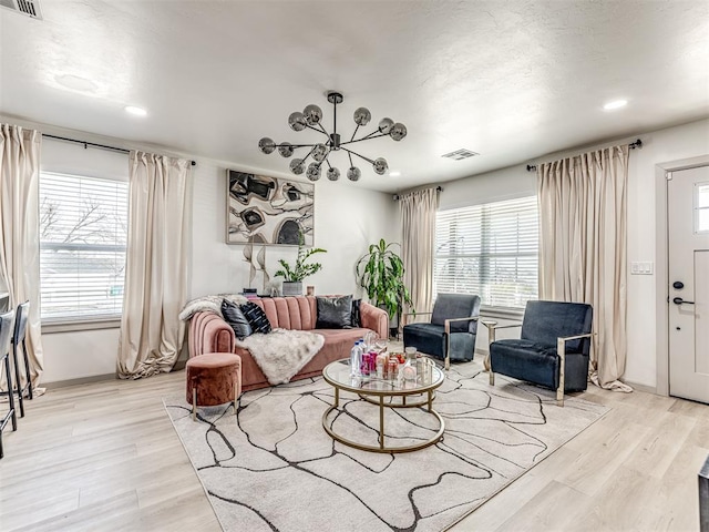 living room featuring an inviting chandelier and light hardwood / wood-style floors