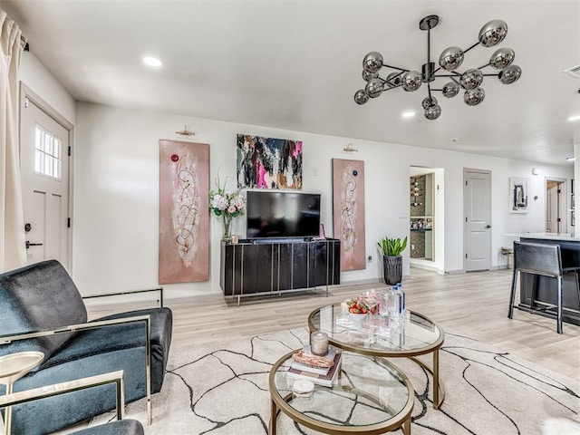 living room with light hardwood / wood-style floors and a chandelier