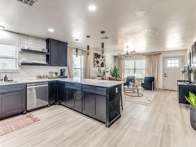 kitchen with decorative light fixtures, dishwasher, kitchen peninsula, and light hardwood / wood-style flooring