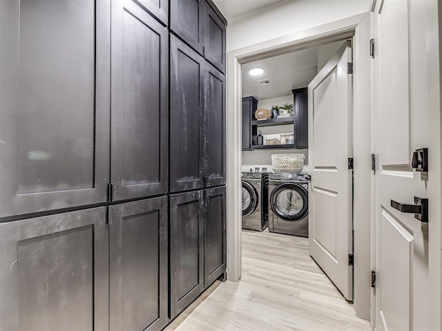 clothes washing area with light hardwood / wood-style flooring and washing machine and dryer