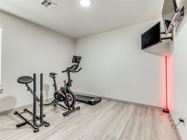 exercise room featuring light wood-type flooring