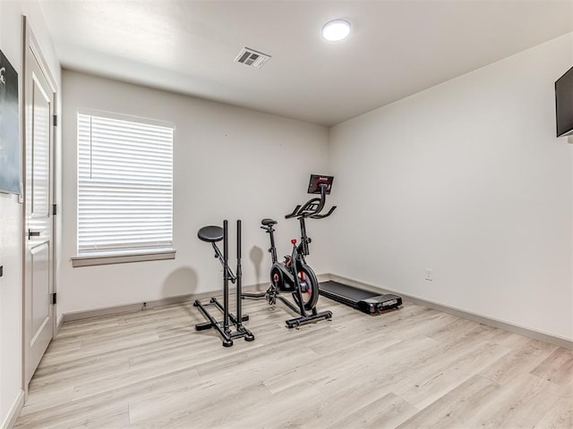 exercise room with light hardwood / wood-style floors