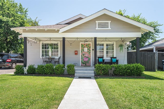 bungalow featuring a front lawn and covered porch