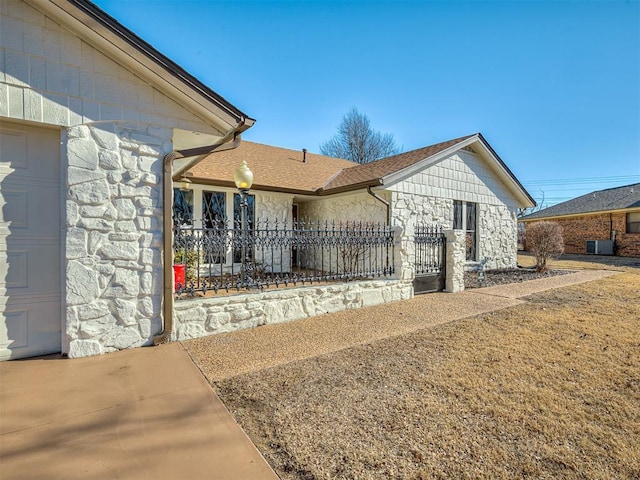 exterior space with a garage and cooling unit