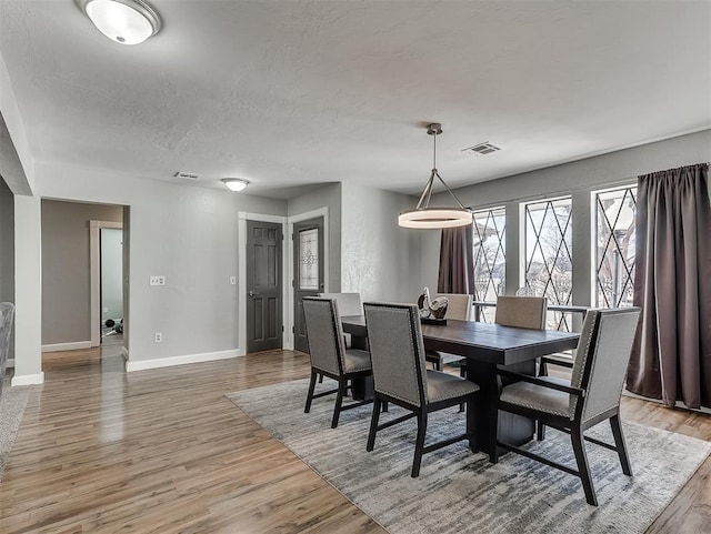 dining area featuring hardwood / wood-style floors and a textured ceiling