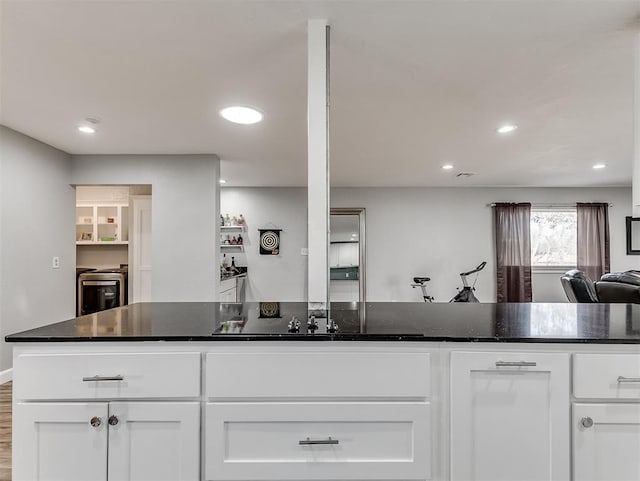 kitchen featuring dark stone counters and white cabinetry