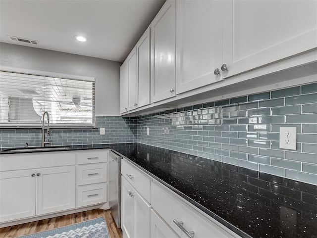 kitchen featuring sink, white cabinets, decorative backsplash, and light hardwood / wood-style floors