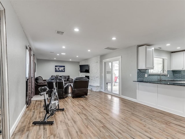 workout area with sink and light wood-type flooring